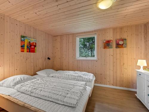 a bedroom with a bed in a wooden wall at Holiday Home Teija - 600m to the fjord by Interhome in Skjern