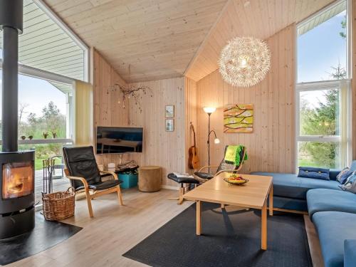 a living room with a blue couch and a fireplace at Holiday Home Teija - 600m to the fjord by Interhome in Skjern