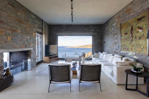 a living room with a white couch and a stone wall at Selene in Ligia