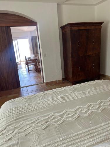 a bedroom with a large bed and a dresser at Beachfront Condominium in Tulum in Tulum