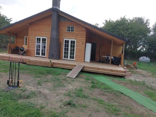 a log cabin with a porch and a gambrel at Holiday Home Lillebror - 900m from the sea by Interhome in Rødby
