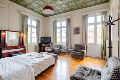 una camera con un letto, due sedie e una TV di FLI I n' II Family Listed Inn since 1850 a Nauplia