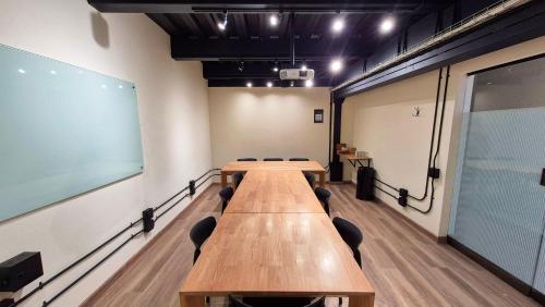 a conference room with a long wooden table and chairs at Hotel Santiago de Arma in Rionegro