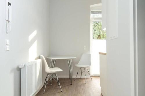 a dining room with a table and two chairs at ChillingHouse Apartments Siegburg in Siegburg