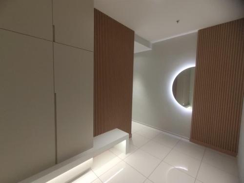 a room with a round mirror and a white wall at Onsen Premium Suites @ Tambun Ipoh in Ipoh