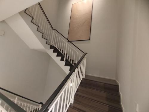 a staircase in a home with white walls and wooden floors at Onsen Premium Suites @ Tambun Ipoh in Ipoh