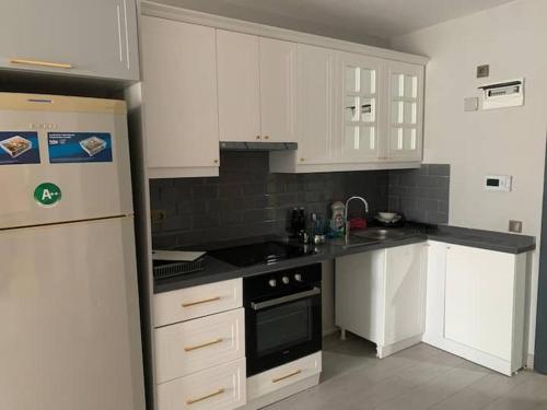 a kitchen with white cabinets and a black stove top oven at Modern & Fully Equipped flat in Safi