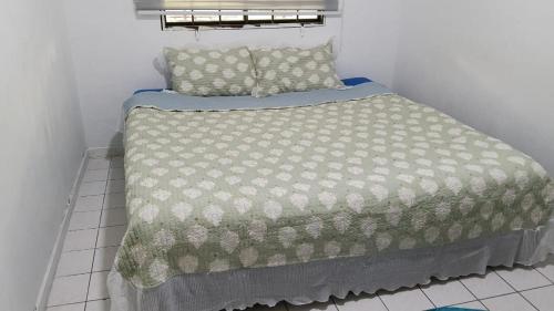 a bed with a comforter and pillows in a room at Apartment Seaview beach pd in Port Dickson