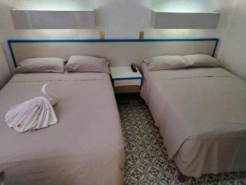 two beds sitting next to each other in a room at HOTEL OLIDEN in Coatzacoalcos