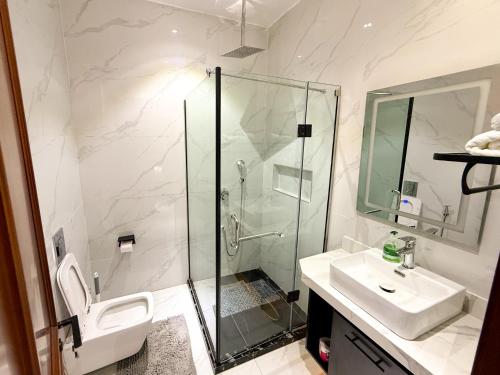 a bathroom with a shower and a toilet and a sink at Ncomhome Luxury Villa in Lekki
