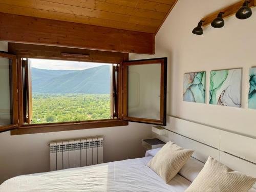 a bedroom with a bed and a large window at Vista Pirineos, wifi y petfriendly in Gavín