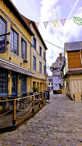 a street with a group of buildings and tables at Le Cocon Suspendu in Pont-Audemer