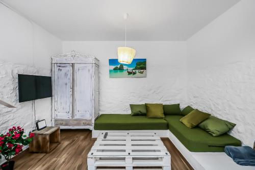 a living room with a green couch and a tv at Casa Bonita Peaceful Home in Ingenio