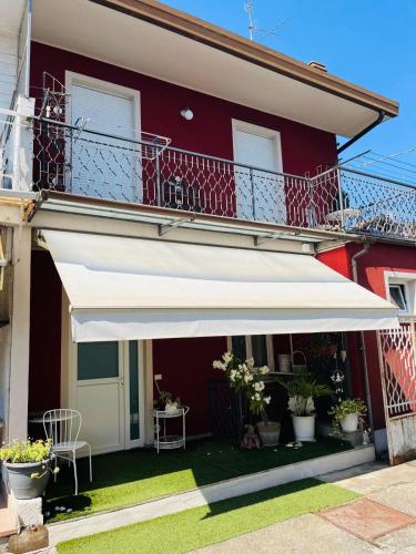 a white awning on the side of a red building at Domus Eleonora tra Laghi e Malpensa MXP in Sesto Calende