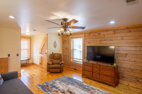 a living room with a ceiling fan and a television at Fish, Soak, Play- River Song Retreat in Crumpler