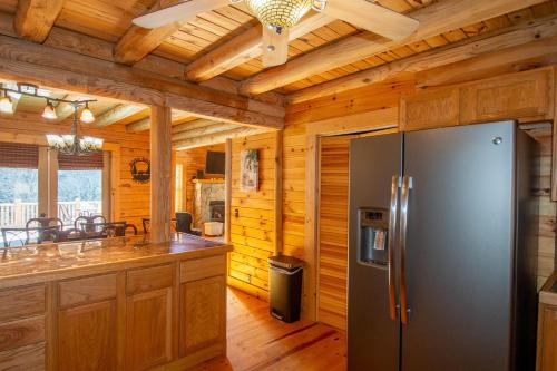 a kitchen with a refrigerator and wooden walls at Fish, Soak, Play- River Song Retreat in Crumpler