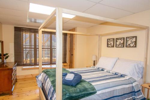 a bedroom with a bed and a large window at Fish, Soak, Play- River Song Retreat in Crumpler