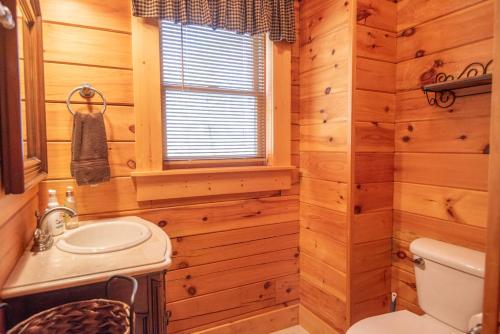 a bathroom with a sink and a toilet and a window at West Jefferson Cabin- Hot Tub, Fireplace, Sleeps 7 in West Jefferson