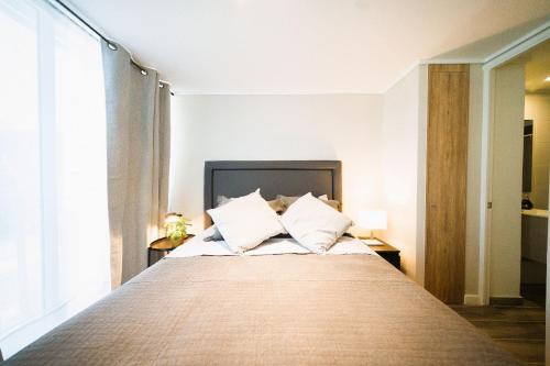 a bedroom with a large bed with two pillows at Luxury con Vista en Irarrázaval - Estadio Nacional in Santiago