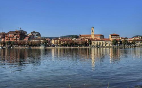 ein großer Wasserkörper mit einer Stadt im Hintergrund in der Unterkunft Domus Eleonora tra Laghi e Malpensa MXP in Sesto Calende