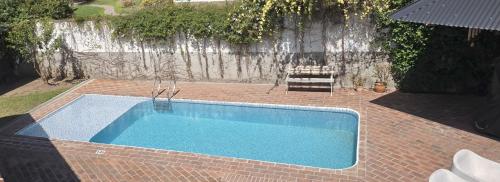 a swimming pool sitting on a brick floor with at Cabañas 57 in Villa Carlos Paz