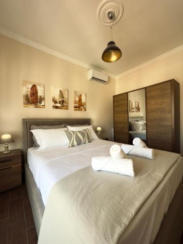 a bedroom with a large bed with towels on it at Benoikon House With Free Private Parking in Serres