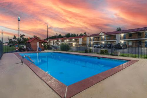 a pool at a resort with a sunset at Best Western Acworth Inn in Acworth