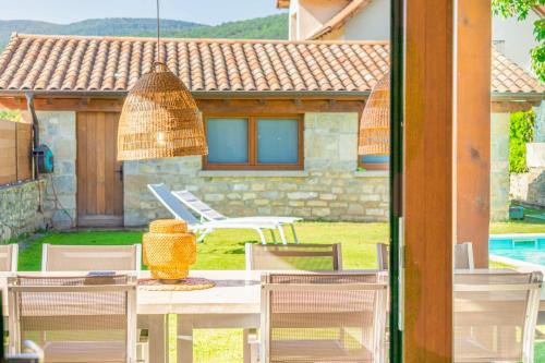 a table and chairs with a vase on top of it at Acogedora casa rural con jardín próxima a Pamplona in Larrasoaña