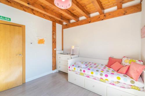 a bedroom with a bed and a wooden ceiling at Acogedora casa rural con jardín próxima a Pamplona in Larrasoaña