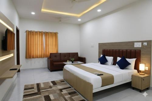 a bedroom with a large bed and a couch at Hotel JK Height's Miyapur, Near Lingampally Railway Station in Lingampalli