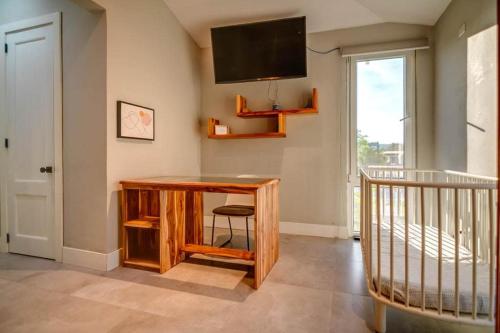 a room with a desk and a television on the wall at Family Surf Villa with Resort Amenities at Venao in Playa Venao