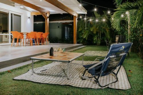 a patio with a table and a chair and a bottle of wine at Family Surf Villa with Resort Amenities at Venao in Playa Venao
