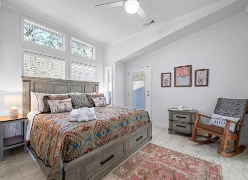 une chambre avec un lit, une chaise et des fenêtres dans l'établissement Broken Bow Cabin with Hot Tub, Deck & BBQ, à Broken Bow