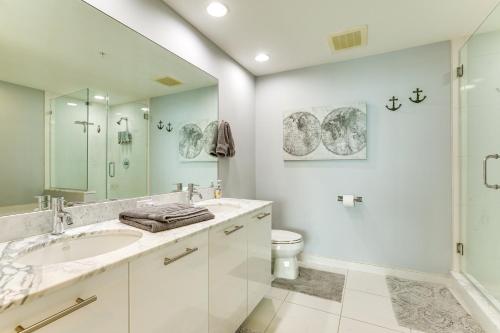 a white bathroom with a sink and a toilet at Heated Pool Access! Waterfront Fort Myers Condo in Fort Myers