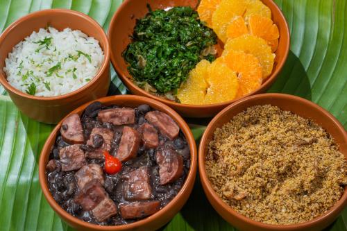 four bowls filled with different types of food on a plate at Soledade Bangalôs - Kauli Seadi in Macau