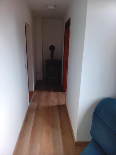 a hallway with a room with white walls and a wooden floor at Casa Sofia in Malonno