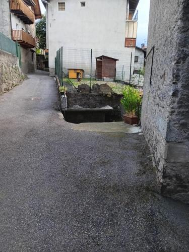 an empty street with a building and a fence at Casa Sofia in Malonno
