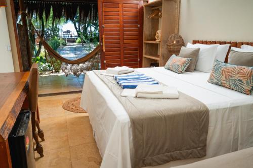 a bedroom with two beds with towels on them at Soledade Bangalôs - Kauli Seadi in Macau