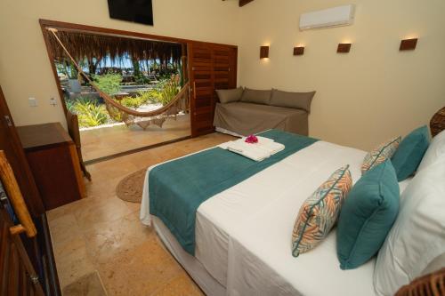 a bedroom with a bed and a couch and a window at Soledade Bangalôs - Kauli Seadi in Macau
