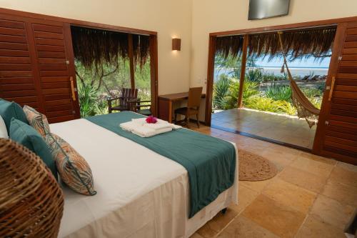 a bedroom with a bed with a view of the ocean at Soledade Bangalôs - Kauli Seadi in Macau