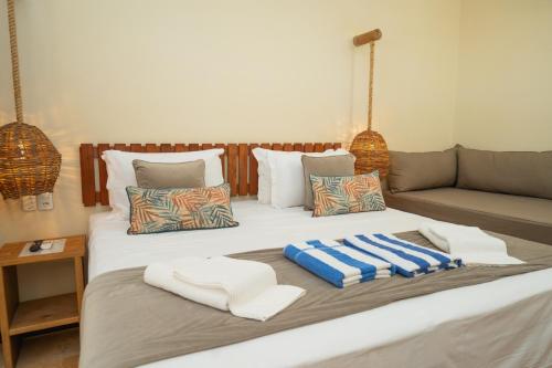 a bed with towels and a couch in a room at Soledade Bangalôs - Kauli Seadi in Macau
