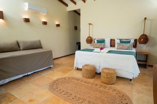 a living room with a bed and a couch at Soledade Bangalôs - Kauli Seadi in Macau