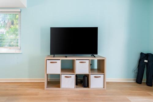 einen TV auf einem TV-Stand in einem Wohnzimmer in der Unterkunft 2BR Stylish Retreat with BBQ Pool & Beach in Indian Harbour Beach