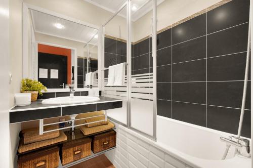 a bathroom with a sink and a mirror at Le Jardin des Muses - T3 climatisé avec terrasse, Piscine et Parking in Toulouse
