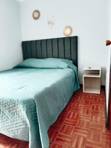 a bedroom with a bed with a green comforter at Hotel del centro rancagua in Rancagua