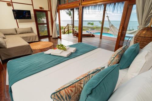 a bedroom with a large bed with a view of the ocean at Soledade Bangalôs - Kauli Seadi in Macau