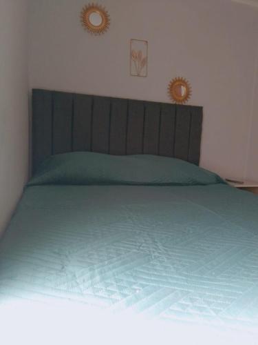 a bedroom with a green bed with two mirrors on the wall at Hotel del centro rancagua in Rancagua