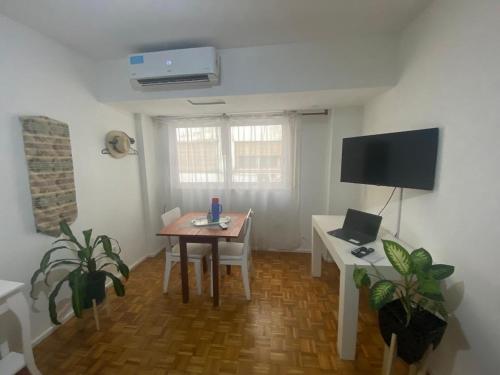 a room with a table and a tv and a table and chairs at Palermo Botánico in Buenos Aires