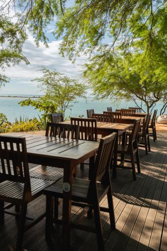 a row of wooden tables and chairs on a deck at Soledade Bangalôs - Kauli Seadi in Macau