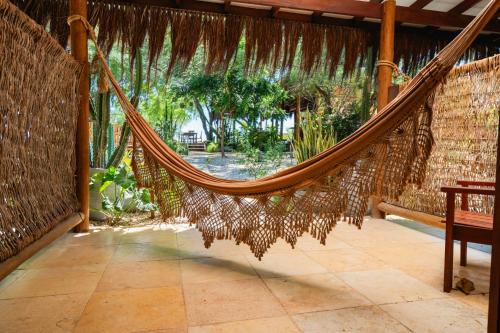 a hammock in a house with a patio at Soledade Bangalôs - Kauli Seadi in Macau